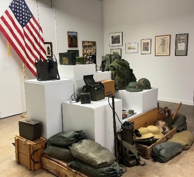 A collection of soliers' belongings, artfully arraged on pedestals.